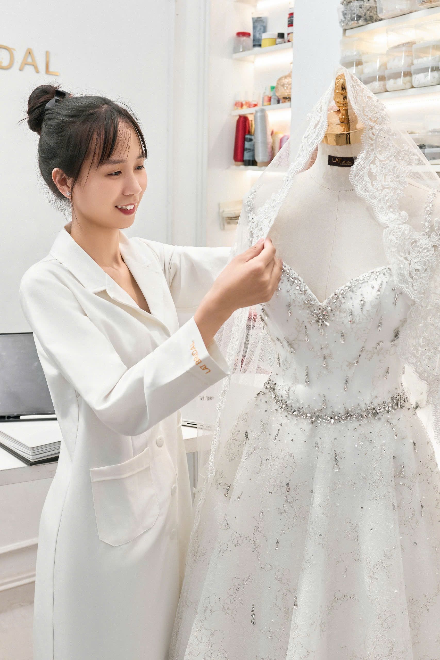 Hai đôi bàn tay đang ghim đính kết pha lê lên thân áo