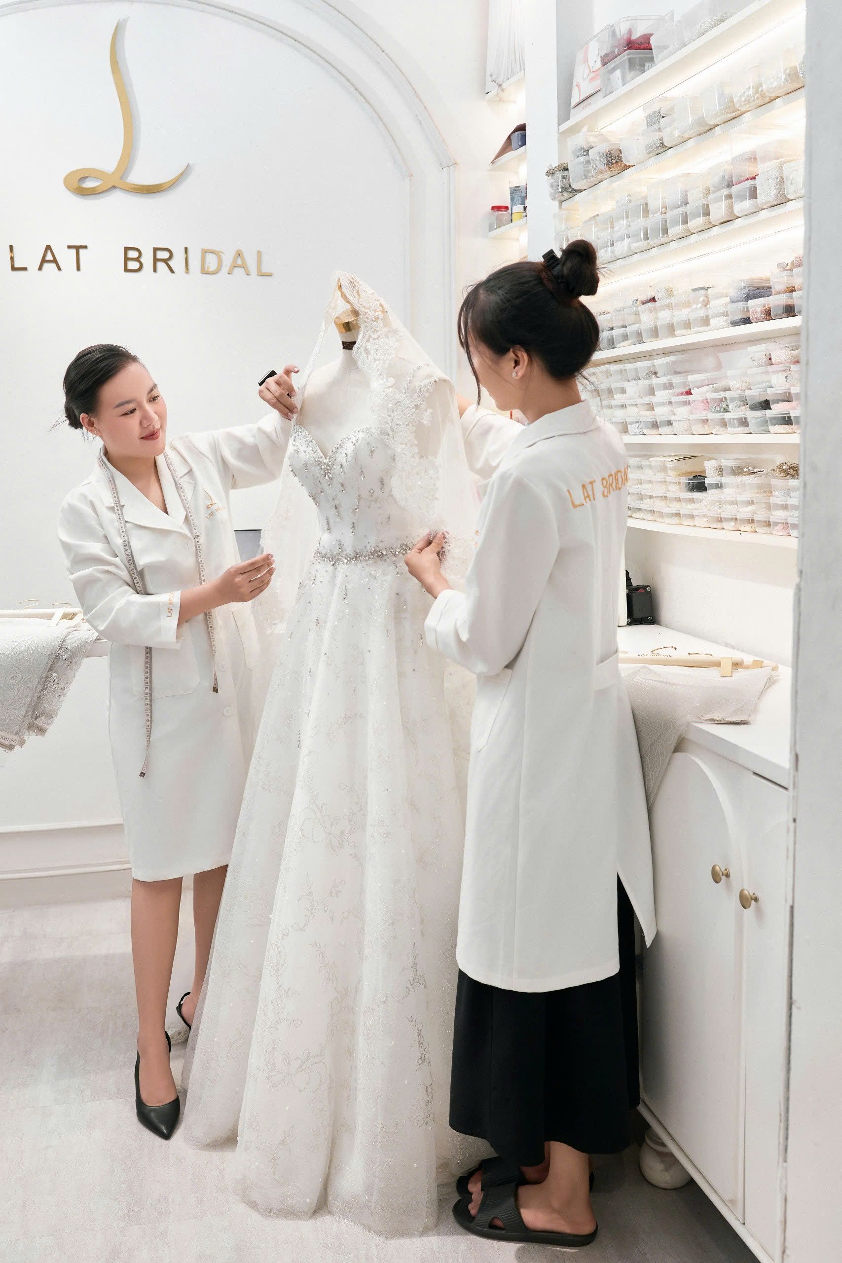 Cận cảnh đôi bàn tay đang ghim đính kết lên thân áo